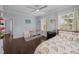 Bright bedroom with hardwood floors, ceiling fan, two windows, and a charming rainbow-themed bedspread at 5002 W Homer Ave, Tampa, FL 33629