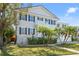 Charming two-story home featuring a balcony, manicured lawn, and decorative palm trees enhancing its curb appeal at 5002 W Homer Ave, Tampa, FL 33629