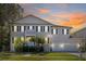 Two-story home with decorative palm trees and two-car garage, set against a stunning sunset sky at 5002 W Homer Ave, Tampa, FL 33629