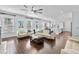 Expansive living room with hardwood floors, comfortable seating, ample natural light, and an open flow to the kitchen area at 5002 W Homer Ave, Tampa, FL 33629