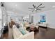 Open-concept living area with hardwood floors, neutral furniture, fan, and seamlessly connected to a modern kitchen at 5002 W Homer Ave, Tampa, FL 33629