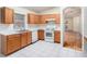 Kitchen features wood cabinets, white appliances, and a view into the adjacent dining area at 11440 Misty Isle Ln, Riverview, FL 33579