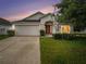 House exterior at dusk with garage and landscaping at 11440 Misty Isle Ln, Riverview, FL 33579