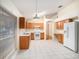 Bright kitchen with wood cabinets, white appliances, and tile flooring at 11440 Misty Isle Ln, Riverview, FL 33579