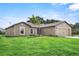 Tan one-story house with a two-car garage and lush lawn at 12461 Patsy Ave, Port Charlotte, FL 33981