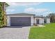 Modern house with gray garage door and landscaped lawn at 5461 Kempson Ln, Port Charlotte, FL 33981