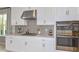 Modern kitchen with white cabinets, stainless steel appliances, and quartz countertops at 10571 Piedra Dr, Palmetto, FL 34221