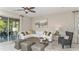 Spacious living room with a large sectional sofa, ample natural light, and access to the backyard at 10571 Piedra Dr, Palmetto, FL 34221