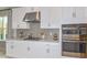 Modern kitchen with white cabinets, stainless steel appliances, and geometric backsplash at 10575 Piedra Dr, Palmetto, FL 34221