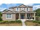 Two-story home with taupe exterior, white shutters, and a covered porch at 7938 Hampton Lake Dr, Tampa, FL 33647