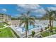 Outdoor community pool surrounded by a white fence, palm trees, lounge furniture and manicured landscaping near a lake at 3753 Lake Bayshore Dr # H305, Bradenton, FL 34205