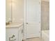 Bathroom with white vanity, a door and tiled walls at 32298 Wetland Bird Vw, San Antonio, FL 33576