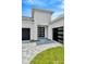 Modern home with white exterior, black double front doors, and paver driveway at 32298 Wetland Bird Vw, San Antonio, FL 33576