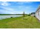 Spacious backyard with pond view, lush lawn, and screened patio at 32298 Wetland Bird Vw, San Antonio, FL 33576