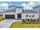 Modern two-story house with a white exterior, gray roof, and a paver driveway at 32298 Wetland Bird Vw, San Antonio, FL 33576