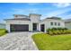 Modern two-story house with a white exterior, gray roof, and a paver driveway at 32298 Wetland Bird Vw, San Antonio, FL 33576