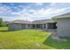 Backyard view of the house with a screened patio and grassy lawn at 31645 Bugle Ln, Wesley Chapel, FL 33543