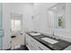Modern bathroom features dual sinks, a marble countertop, and sleek fixtures, with a glimpse into the bedroom at 814 S Bayside Dr, Tampa, FL 33609
