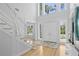 Bright foyer showcasing high ceilings, hardwood floors, a staircase, and a decorative rug at 814 S Bayside Dr, Tampa, FL 33609