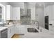 Bright kitchen features white cabinets, stainless steel appliances, stone countertops and backsplash detail at 814 S Bayside Dr, Tampa, FL 33609