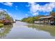 Waterfront property featuring boat docks on the canal, enhanced by mature trees under a bright blue sky at 814 S Bayside Dr, Tampa, FL 33609