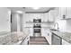 Modern kitchen featuring white cabinets, granite countertops, and stainless steel appliances at 1508 Fort Duquesna Dr, Sun City Center, FL 33573