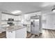 Modern kitchen featuring white cabinets, granite countertops, and stainless steel appliances at 1508 Fort Duquesna Dr, Sun City Center, FL 33573