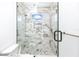 Elegant shower with marble tile, glass enclosure, and a small window at 1308 E Columbus Dr # 2, Tampa, FL 33605