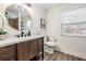 Well-lit bathroom featuring a modern vanity, toilet, round mirror, and wood-look flooring at 4304 W Laurel St, Tampa, FL 33607