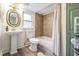 Charming bathroom with a pedestal sink, tub and shower combo, and wood-look flooring at 4304 W Laurel St, Tampa, FL 33607