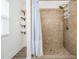 Tiled walk-in shower with a rainfall shower head and built-in storage shelves at 4304 W Laurel St, Tampa, FL 33607