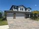 Two-story house with a three-car garage and paver driveway at 12964 Willow Grove Dr, Riverview, FL 33579