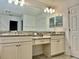 Double vanity bathroom with granite countertop and large mirror at 12964 Willow Grove Dr, Riverview, FL 33579