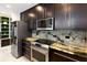 Modern kitchen with dark cabinets, granite counters and stainless steel appliances at 777 N Ashley Dr # 2601, Tampa, FL 33602