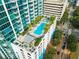 Aerial view of a luxurious rooftop pool with lounge area and palm trees at 777 N Ashley Dr # 2601, Tampa, FL 33602