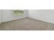 Well-lit bedroom with a window and neutral carpeting at 4939 Eagle Rock Dr, Wimauma, FL 33598
