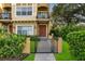 Charming two-story home featuring a front balcony, gated entrance, and lush landscaping at 111 N Albany Ave # 16, Tampa, FL 33606