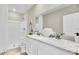 Bathroom featuring double sinks with marble countertops, white cabinets, and a walk-in shower at 814 Flash Dr, Clearwater, FL 33765