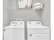Functional laundry room featuring a white washer and dryer with shelving for storage at 814 Flash Dr, Clearwater, FL 33765