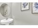 Stylish powder room with pedestal sink and decorative artwork enhances this well-appointed home at 814 Flash Dr, Clearwater, FL 33765