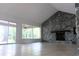 Spacious living room with a stone fireplace and view of the backyard through large windows at 16308 Rock Lake Dr, Odessa, FL 33556