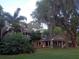 Ranch home with a secondary structure, lush landscaping, and large trees at 16308 Rock Lake Dr, Odessa, FL 33556