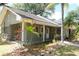 Charming house exterior with a covered porch and stone accents, surrounded by tropical landscaping at 16308 Rock Lake Dr, Odessa, FL 33556