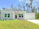 New construction home with gray siding, white trim, and a grassy lawn at 17423 Metcalf Ave, Port Charlotte, FL 33954