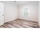 Spacious bedroom with wood-look flooring and a window with plantation shutters at 18078 Spartonvail Ave, Port Charlotte, FL 33954