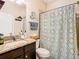 Bathroom with shower/tub combo, granite countertop, and patterned shower curtain at 29405 Cochiti Lake Dr, San Antonio, FL 33576