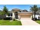 One-story house with tan exterior, attached garage, and landscaped lawn at 29405 Cochiti Lake Dr, San Antonio, FL 33576