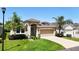 One-story house with tan exterior, attached garage, and landscaped lawn at 29405 Cochiti Lake Dr, San Antonio, FL 33576