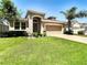 One story house with tan exterior, attached garage and well manicured lawn at 29405 Cochiti Lake Dr, San Antonio, FL 33576