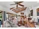 Light-filled living area featuring hardwood floors, exposed beams, and comfortable furniture at 7306 Pelican Island Dr, Tampa, FL 33634